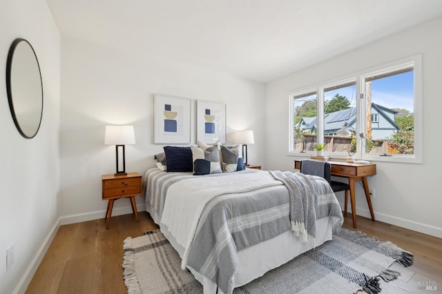 bedroom featuring baseboards and wood finished floors