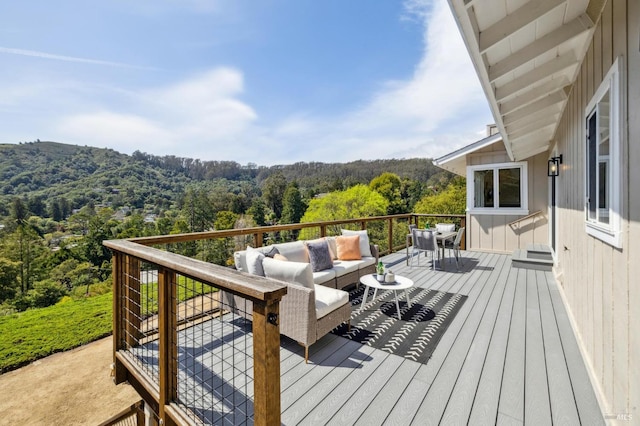 deck featuring an outdoor living space and a view of trees