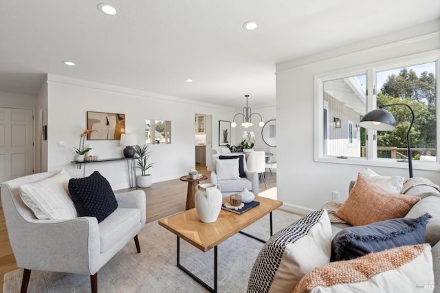 living area featuring light wood-style flooring, baseboards, an inviting chandelier, and a wealth of natural light