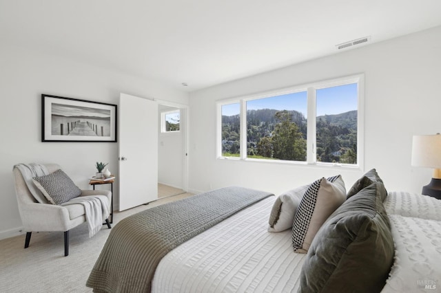 bedroom with light carpet, visible vents, and baseboards