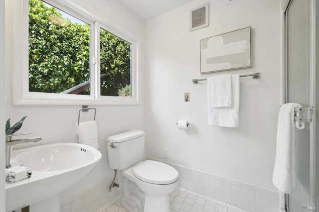 bathroom featuring toilet, a sink, tile patterned flooring, and visible vents