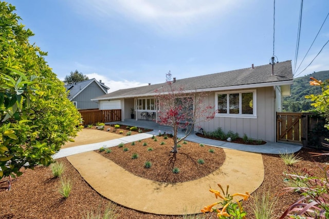 ranch-style home featuring a patio, a gate, board and batten siding, a garage, and fence