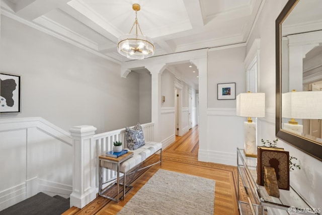 hallway with beamed ceiling, hardwood / wood-style flooring, coffered ceiling, and a notable chandelier