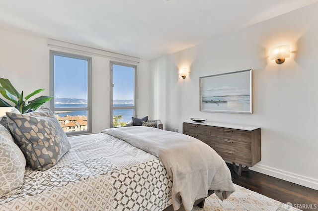 229 Brannan St Unit 12C, San Francisco, CA 94107 - bedroom featuring a water view, dark wood-type flooring, and baseboards