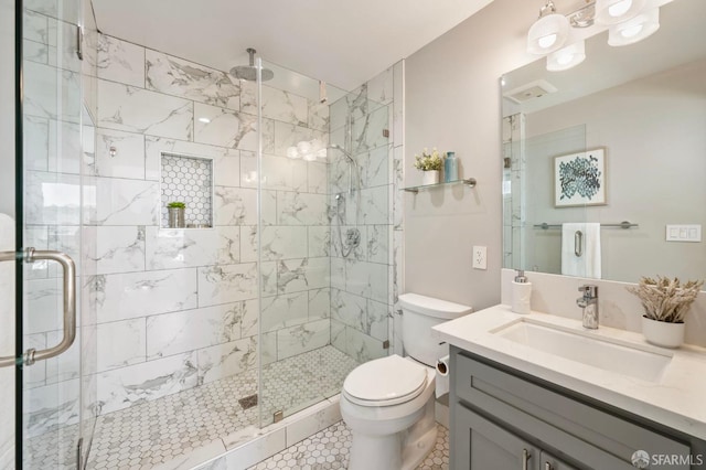 bathroom with tile patterned flooring, vanity, an enclosed shower, and toilet