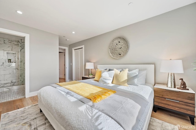 bedroom featuring connected bathroom, a closet, and light hardwood / wood-style flooring