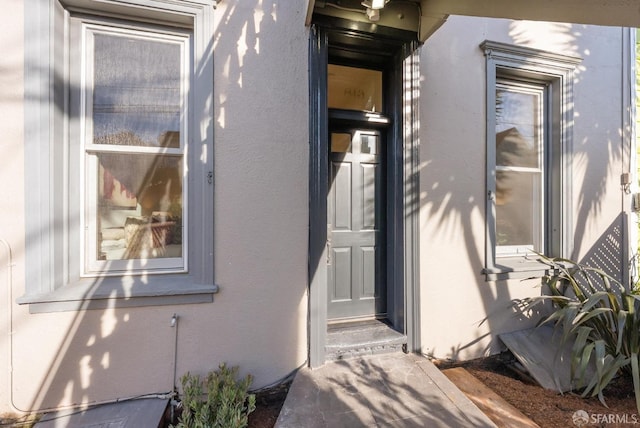 doorway to property with stucco siding