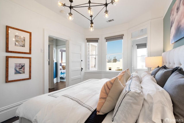 bedroom featuring an inviting chandelier and visible vents