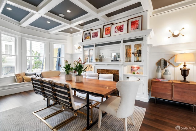 dining space featuring a decorative wall, wood finished floors, a wainscoted wall, coffered ceiling, and beam ceiling