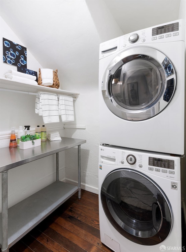 laundry area featuring baseboards, dark wood-style flooring, stacked washer / drying machine, and laundry area