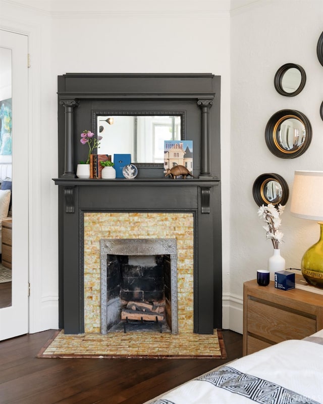 interior details with wood finished floors and a tile fireplace