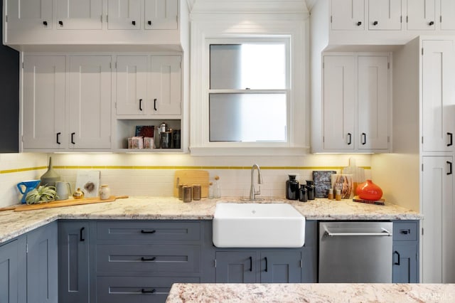 kitchen with white cabinets, stainless steel dishwasher, and a sink