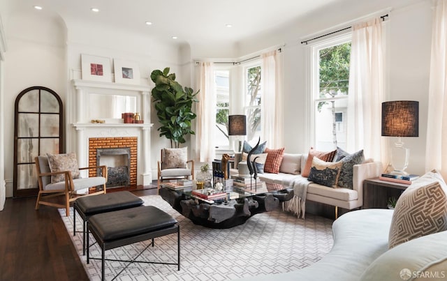 living area featuring recessed lighting, wood finished floors, and a brick fireplace