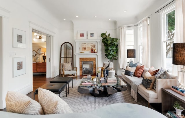 living area with recessed lighting, wood finished floors, and a brick fireplace