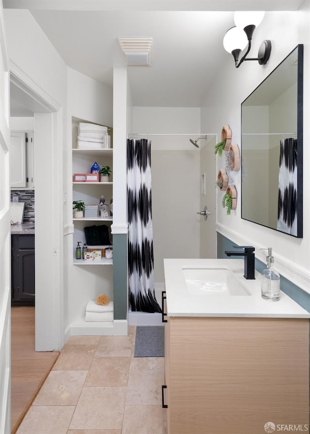 full bathroom featuring vanity, a shower with shower curtain, and visible vents