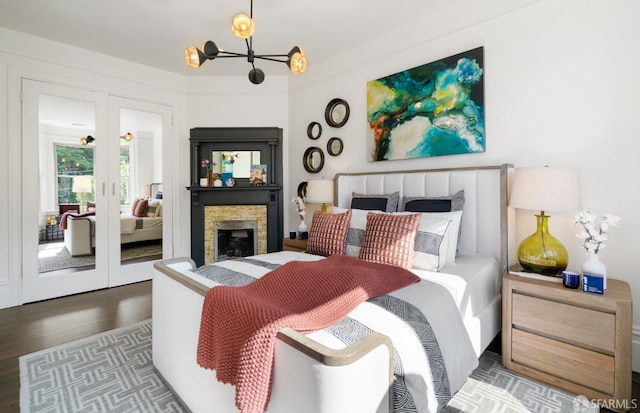 bedroom with wood finished floors, a notable chandelier, and french doors