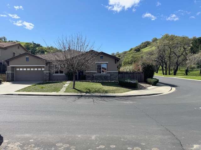 ranch-style house with stucco siding, an attached garage, fence, driveway, and a front lawn