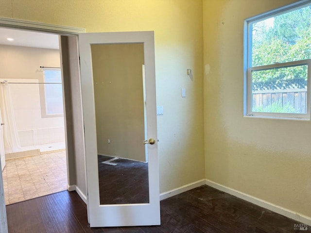 spare room with dark wood-style flooring and baseboards