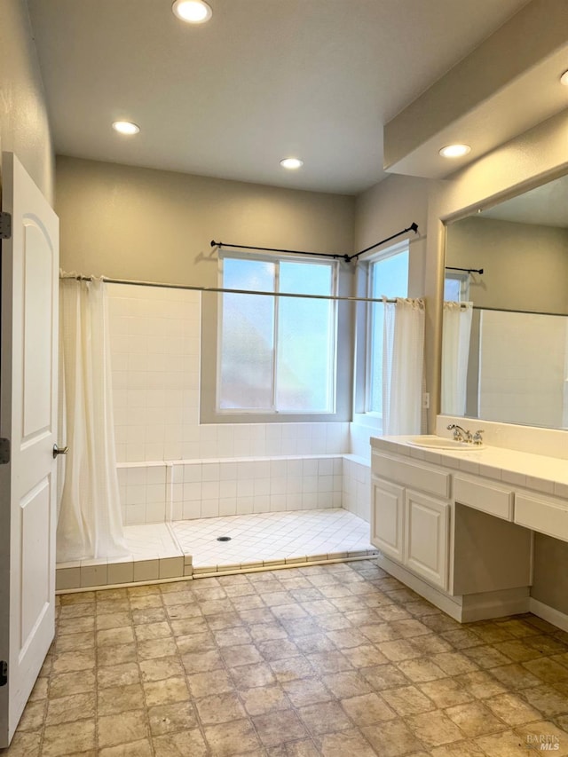 full bathroom with recessed lighting, a tile shower, and vanity