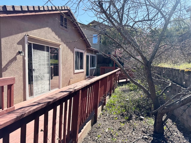 view of side of home with fence and stucco siding