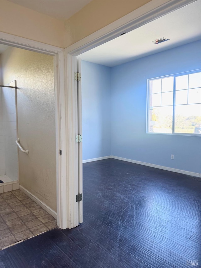 unfurnished room with visible vents, baseboards, and wood finished floors