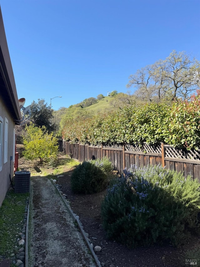 view of yard with fence and cooling unit