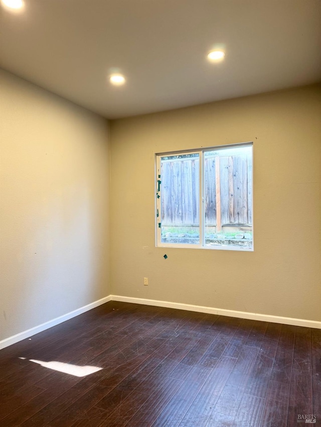 unfurnished room with recessed lighting, wood-type flooring, and baseboards