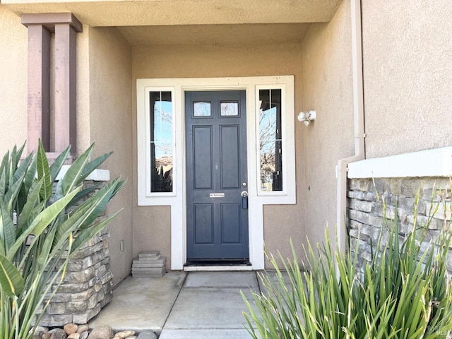 entrance to property featuring stucco siding