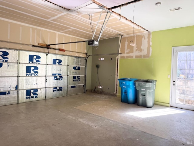 garage with a garage door opener and visible vents