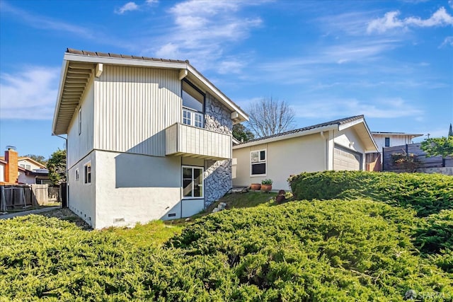 rear view of property featuring crawl space, fence, and an outdoor structure