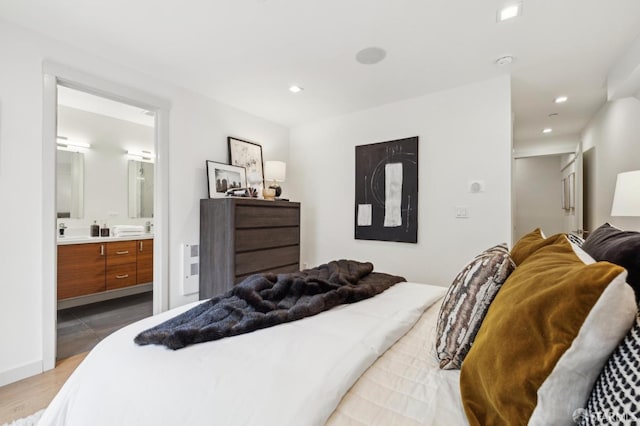 bedroom featuring ensuite bath and light hardwood / wood-style flooring