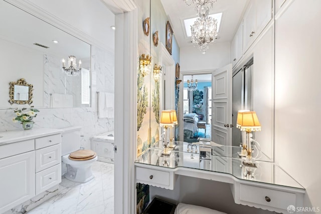 bathroom featuring vanity, tile walls, toilet, and a chandelier