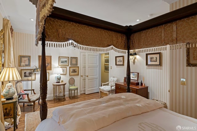 bedroom with ornamental molding and hardwood / wood-style floors