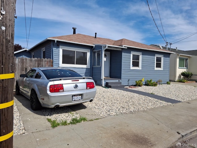 single story home featuring fence and roof with shingles