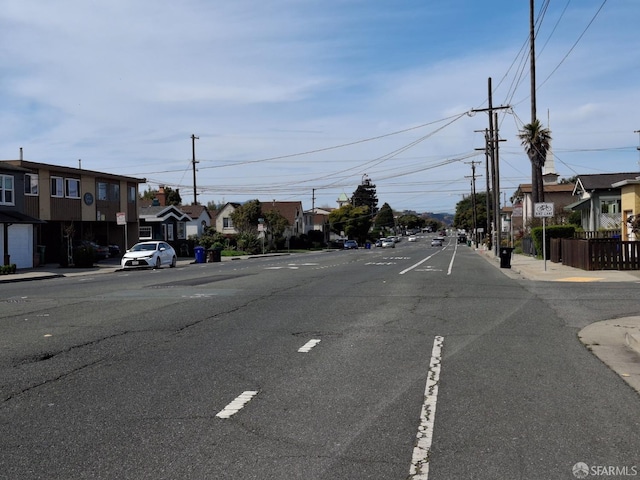 view of street with traffic signs, curbs, sidewalks, and a residential view