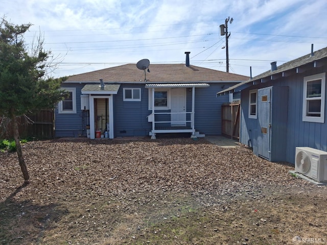 rear view of house with ac unit and fence