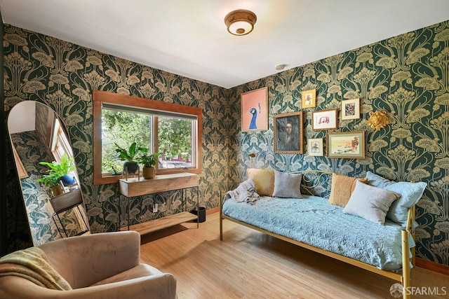 living area with baseboards, wallpapered walls, and wood finished floors