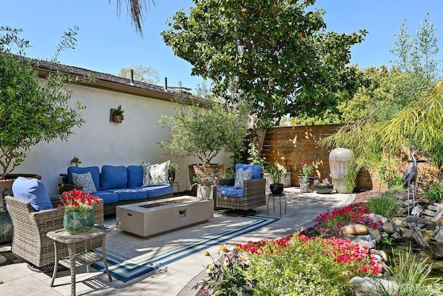 view of patio / terrace featuring fence and an outdoor living space with a fire pit