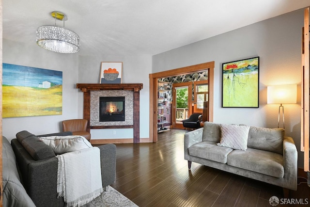living area with an inviting chandelier, a glass covered fireplace, and wood finished floors