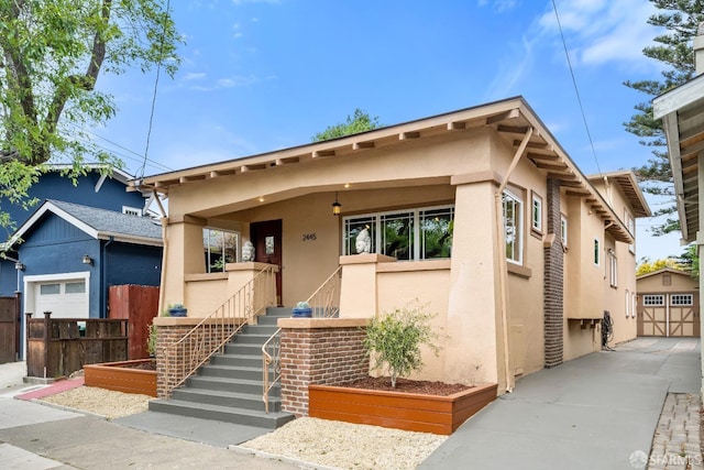 view of front facade with a garage, fence, stairs, and stucco siding