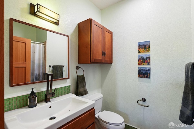 full bath featuring a shower with curtain, vanity, backsplash, and toilet
