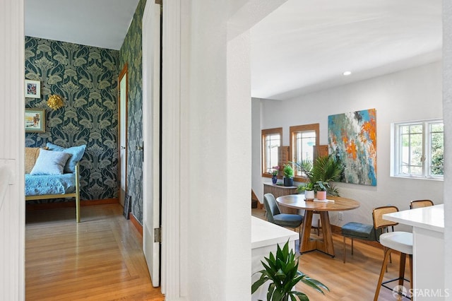 hall with an accent wall, recessed lighting, wallpapered walls, baseboards, and light wood-type flooring