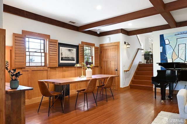 dining area with visible vents, wood finished floors, beam ceiling, and stairway