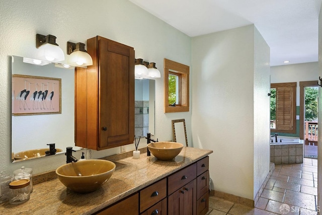 full bath with double vanity, a sink, and a garden tub