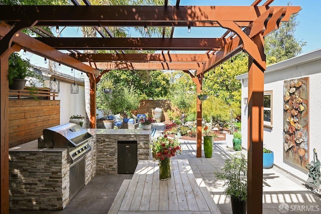 view of patio / terrace with grilling area, an outdoor kitchen, fence, and a pergola