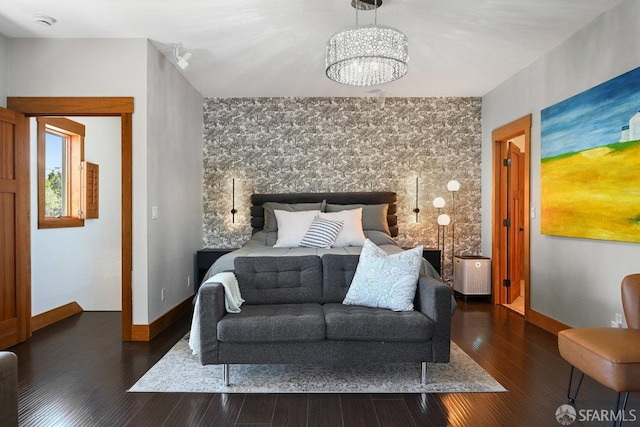 bedroom featuring baseboards, a chandelier, and wood finished floors