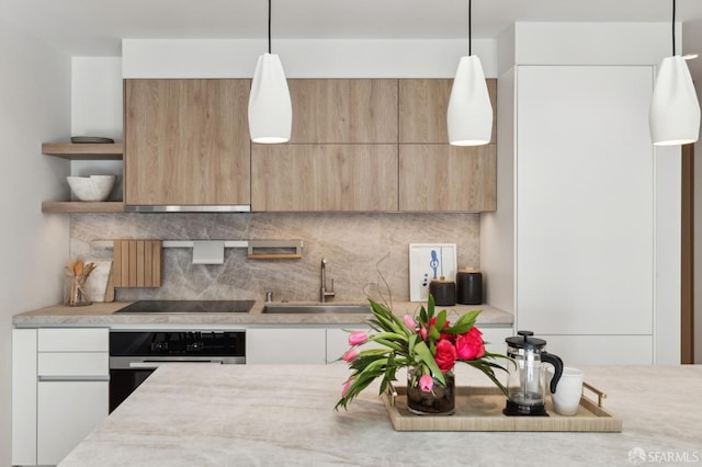 kitchen with white cabinets, pendant lighting, oven, and sink