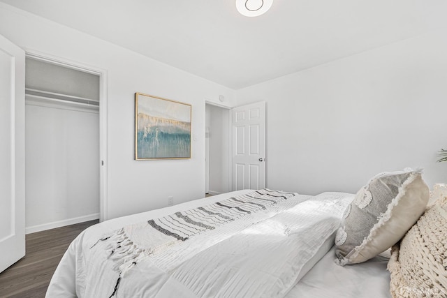 bedroom with dark hardwood / wood-style flooring and a closet