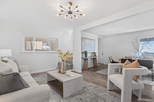 living room with plenty of natural light, hardwood / wood-style floors, and an inviting chandelier