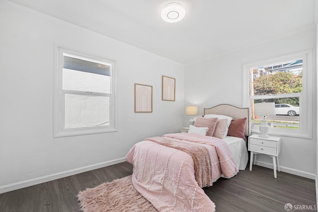 bedroom with multiple windows and dark wood-type flooring